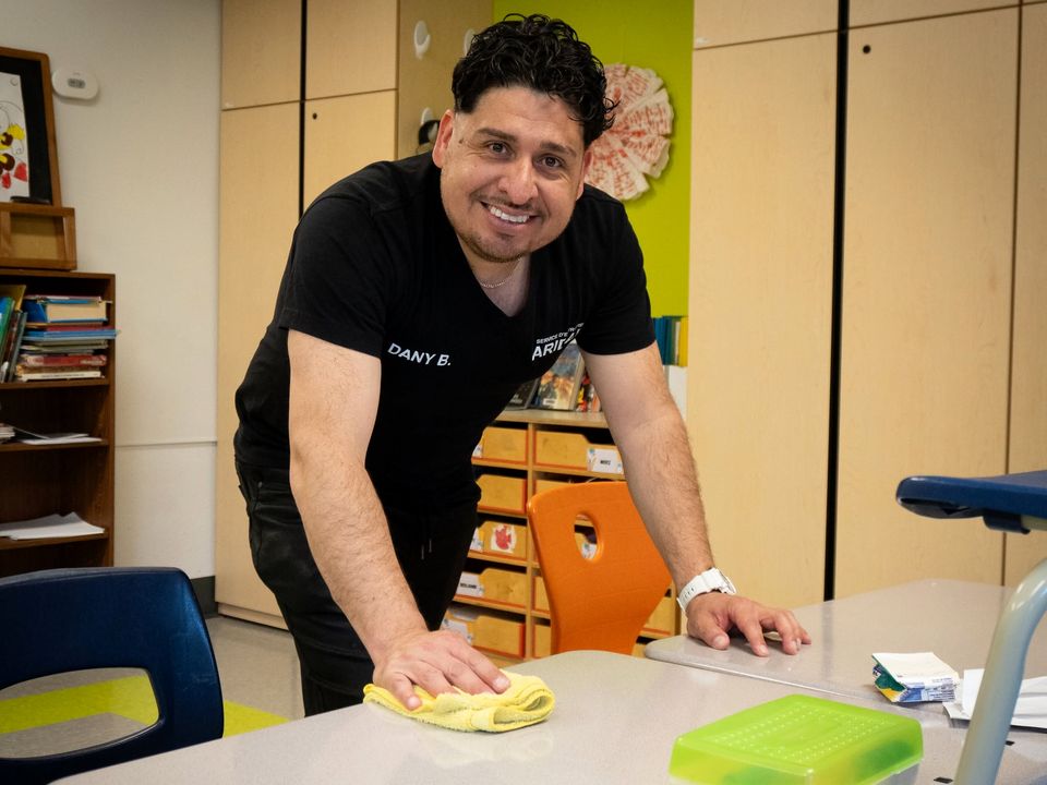 Employé ARIDAN qui essuie une table dans une classe d'école