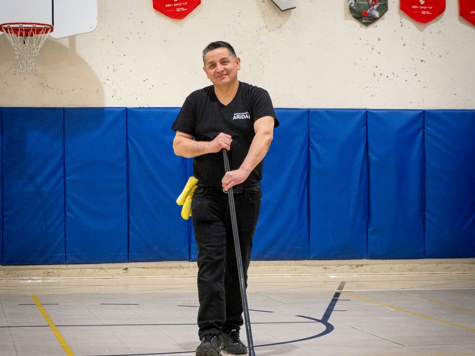 Employé ARIDAN avec une vadrouille dans un gymnase