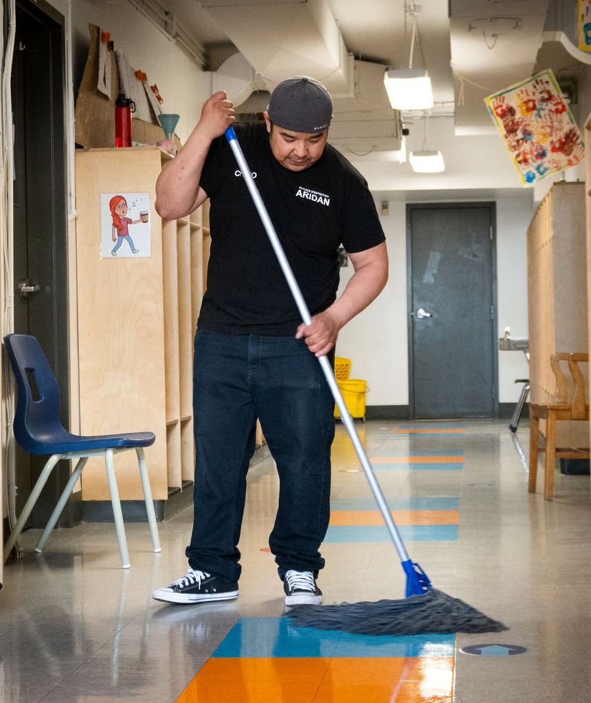 Employé ARIDAN qui passe la vadrouille dans un corridor d'école